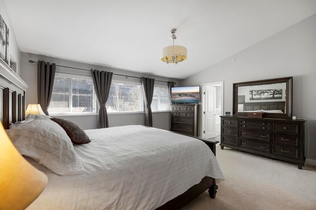 Bedroom featuring vaulted ceiling, a notable chandelier, and light colored carpet | Image 20