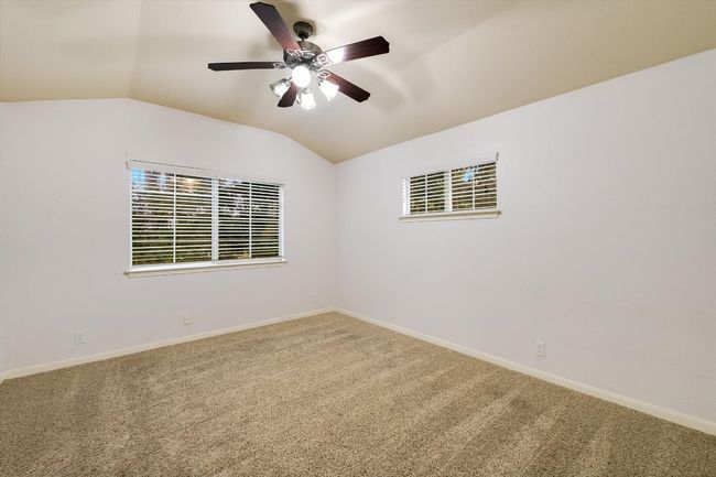 Empty room with lofted ceiling, carpet floors, and ceiling fan | Image 14