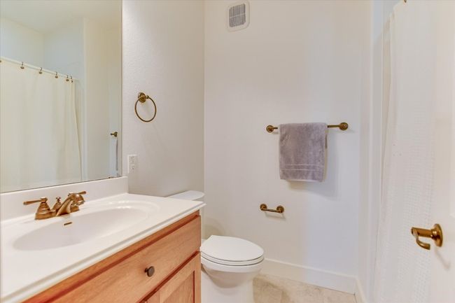 Full bathroom close to second bedroom featuring vanity, tile patterned flooring, and curtained shower | Image 16