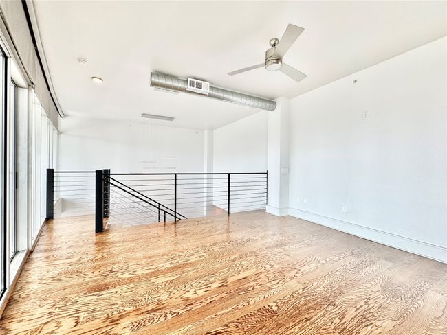 Spare room with wood finished floors, a ceiling fan, and baseboards | Image 9