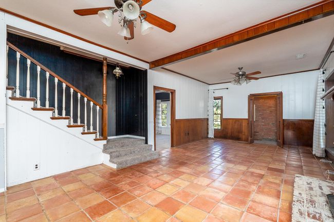 Entrance foyer featuring ceiling fan, wooden walls, and ornamental molding | Image 7