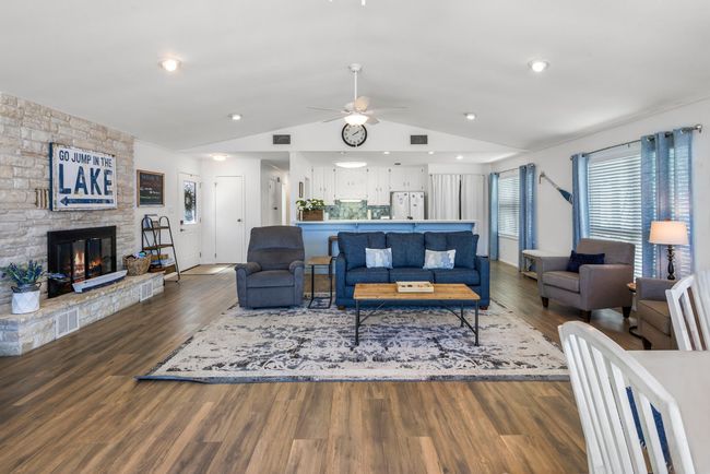 Living room featuring vaulted ceiling, a fireplace, visible vents, and wood finished floors | Image 9