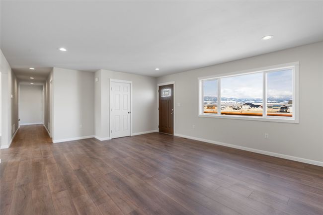 Unfurnished living room featuring dark wood-style flooring, baseboards, and recessed lighting | Image 32