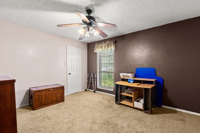Office space with a textured wall, carpet floors, a textured ceiling, and ceiling fan | Image 12