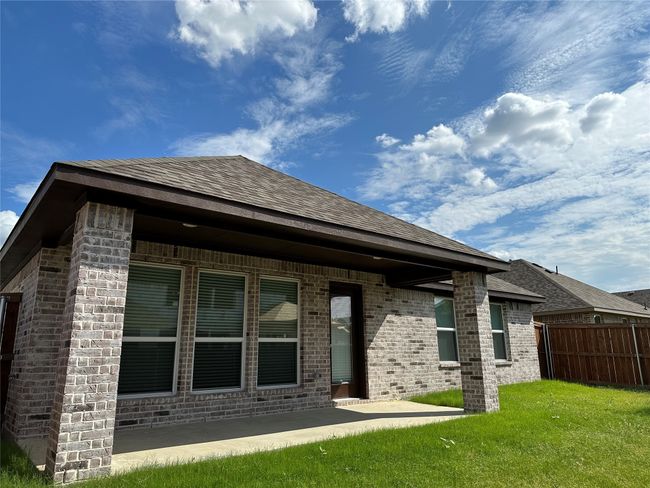 Back of property featuring brick siding, a shingled roof, and a patio | Image 13
