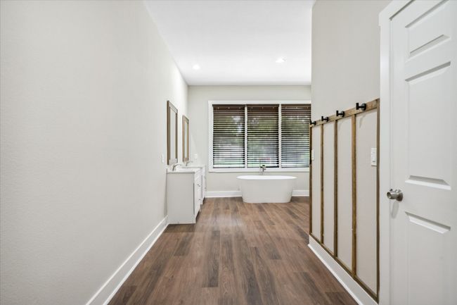 Full bath featuring vanity, wood finished floors, baseboards, a freestanding bath, and recessed lighting | Image 14