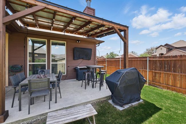 View of patio with outdoor dining area, a grill, and fence | Image 32