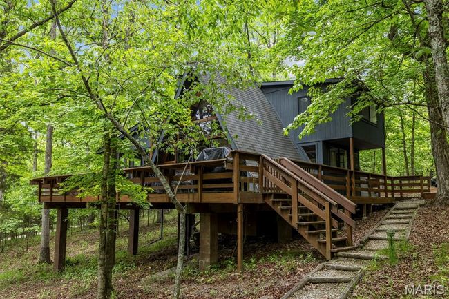 Rear view of property with a deck, stairs, and roof with shingles | Image 50