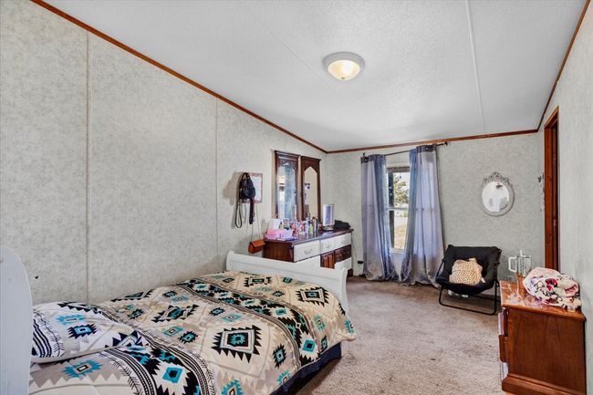 Carpeted bedroom with vaulted ceiling, a textured ceiling, and crown molding | Image 20