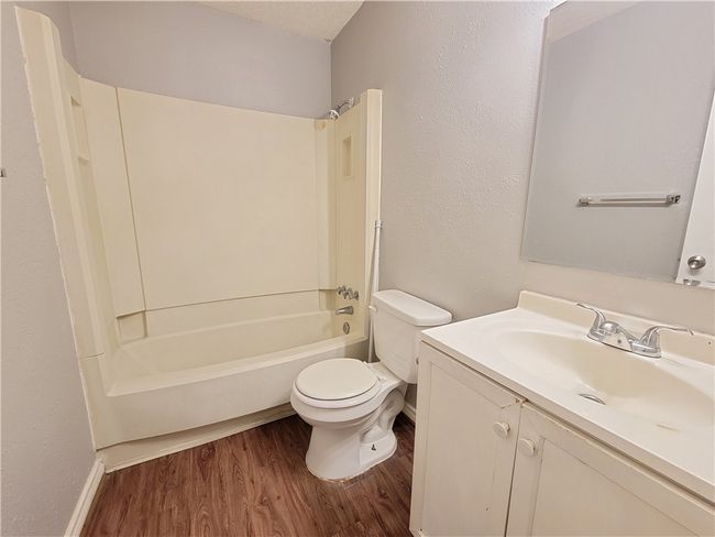Bathroom featuring wood finished floors, vanity, and shower / washtub combination | Image 9