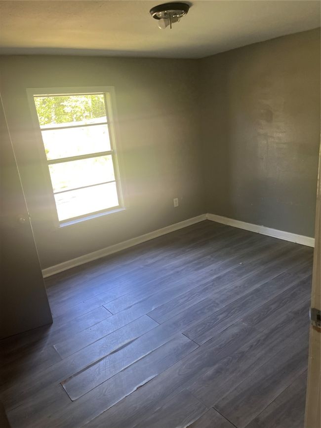 Spare room with baseboards and dark wood-style floors | Image 12