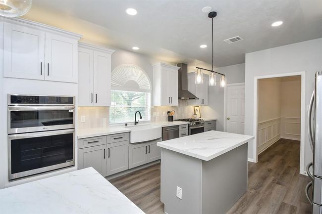 You will love cooking in this kitchen! With three brand-new ovens, including a versatile unit that can switch between conventional and microwave cooking, you will have the best time preparing meals for everyday living and large gatherings. With sous-vide options and plenty of flexibility, this kitchen is built to handle holiday feasts and entertaining with ease! Also, note the spacious utility room with additional space for storage shelves or folding table. | Image 10