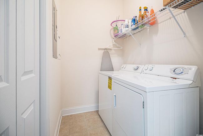Laundry room with washer and dryer, baseboards, and light tile patterned floors | Image 24