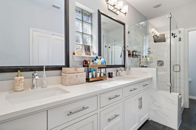 Bathroom featuring double vanity, a marble finish shower, and tile patterned flooring | Image 15