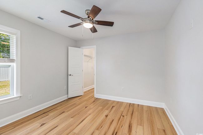 Empty room with light wood finished floors and a ceiling fan | Image 21