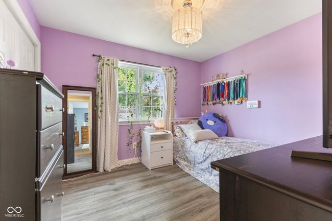bedroom with wood finished floors and a chandelier | Image 16