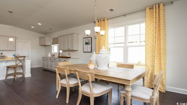 Dining space with visible vents, baseboards, dark wood-style flooring, and a notable chandelier | Image 18