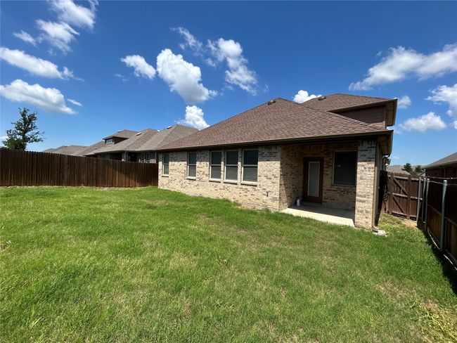 Rear view of house featuring brick siding, roof with shingles, and a patio | Image 33