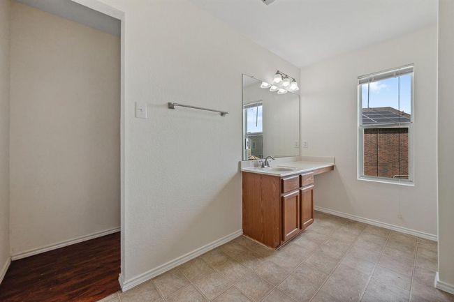 Alternate view of the primary bathroom with vanity and mirror. | Image 18