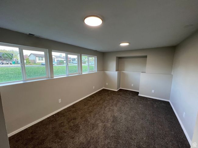 Interior space with baseboards, dark colored carpet, and visible vents | Image 7
