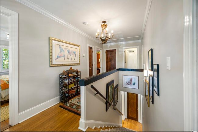 Stairs featuring a chandelier, crown molding, and wood finished floors | Image 17