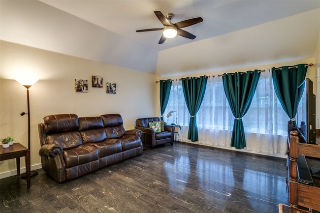 Living area with a ceiling fan, lofted ceiling, and baseboards | Image 18