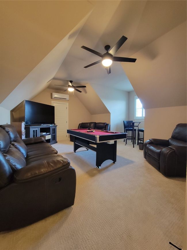 Carpeted bedroom featuring multiple windows, crown molding, a raised ceiling, and ceiling fan | Image 16