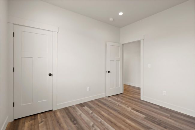 Unfurnished bedroom with a closet, recessed lighting, baseboards, and wood finished floors | Image 21