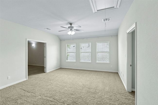 Carpeted spare room featuring attic access, ceiling fan, and baseboards | Image 21