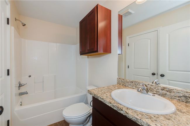 Bathroom with shower / bathing tub combination, vanity, visible vents, and toilet | Image 12