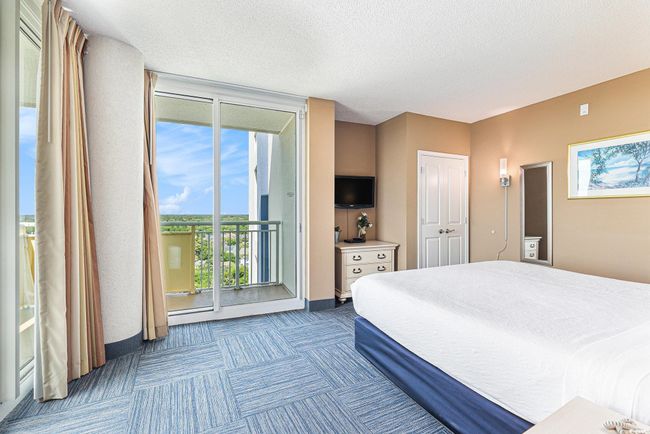 Carpeted bedroom featuring access to outside, a textured ceiling, and baseboards | Image 14