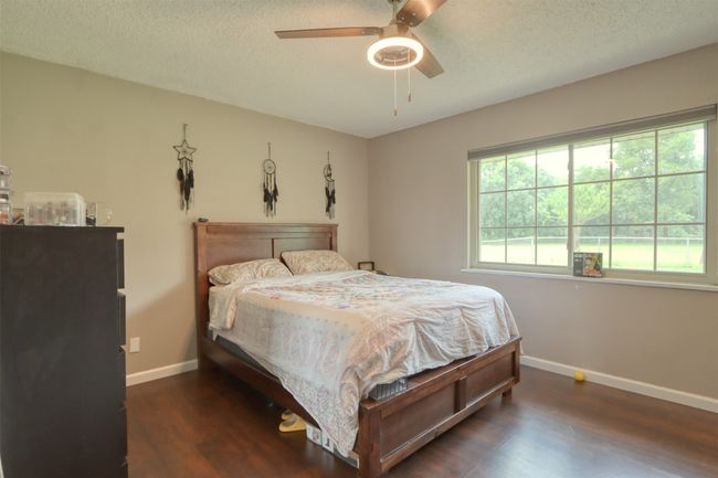 Bedroom with wood finished floors, a textured ceiling, and a ceiling fan | Image 35