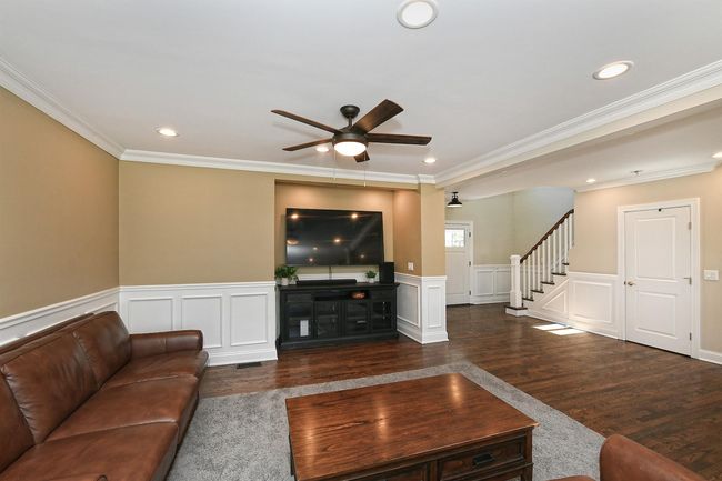 Unfurnished living room featuring wood finished floors, a ceiling fan, stairs, and ornamental molding | Image 20