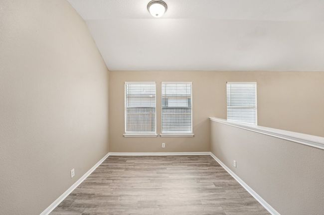 Spare room featuring lofted ceiling, light wood finished floors, and a textured wall | Image 24