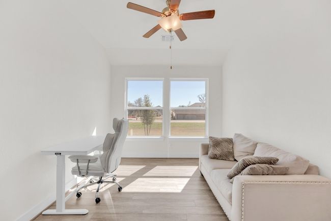 Office area with ceiling fan, lofted ceiling, light wood-style flooring, visible vents, and baseboards | Image 31