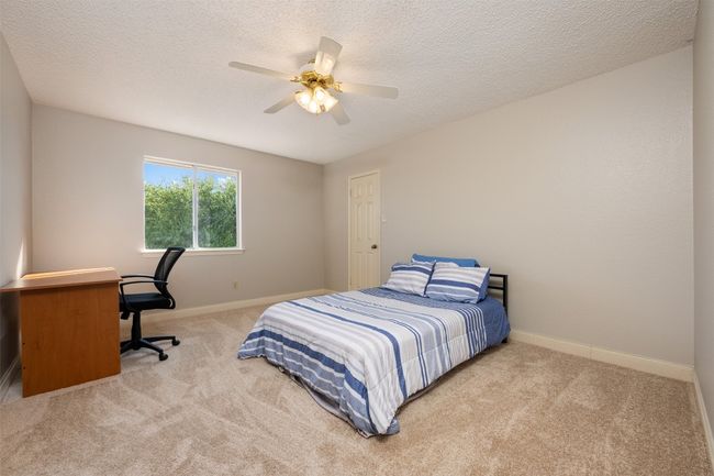 Bedroom with carpet, baseboards, a textured ceiling, and ceiling fan | Image 19