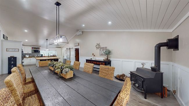Kitchen featuring decorative light fixtures, premium range hood, backsplash, stainless steel appliances, and wood counters | Image 10