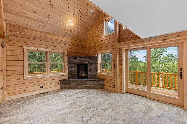 Living room with high vaulted t&g ceiling, light tile floors, and a gas fireplace | Image 19