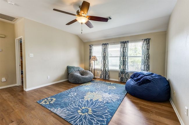 Sitting room with a ceiling fan, wood finished floors, baseboards, and lofted ceiling | Image 21