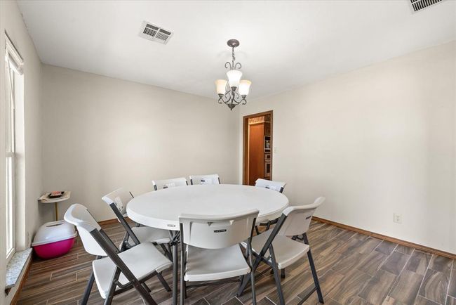 Dining room featuring dark wood-style flooring, a chandelier, and baseboards | Image 10