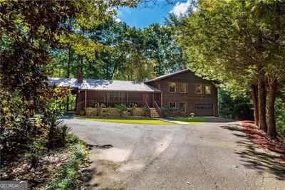 This home is tucked in on the lot with a circular driveway and loads of parking areas. | Image 3