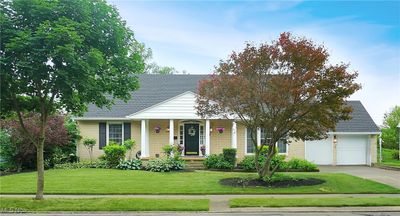 View of front facade with a garage, a front yard, and covered porch | Image 3