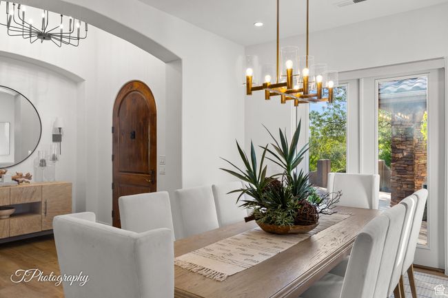 Dining area with a chandelier, wood finished floors, arched walkways, and recessed lighting | Image 20