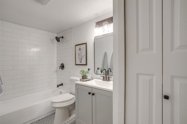 Bathroom featuring vanity, bathtub / shower combination, a textured ceiling, and tile patterned floors | Image 19