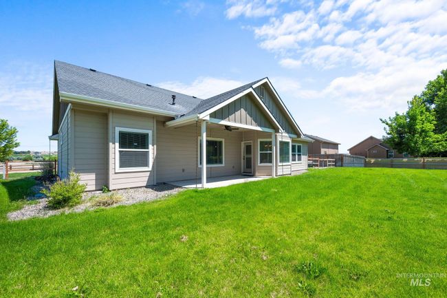 Back of house featuring board and batten siding, a patio, ceiling fan, and a shingled roof | Image 41