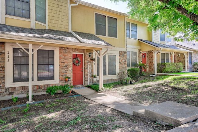 Townhome / multi-family property with brick siding, stone siding, and roof with shingles | Image 9