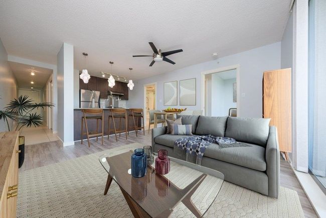 Living area featuring a textured ceiling, ceiling fan, and light wood-style floors | Image 8