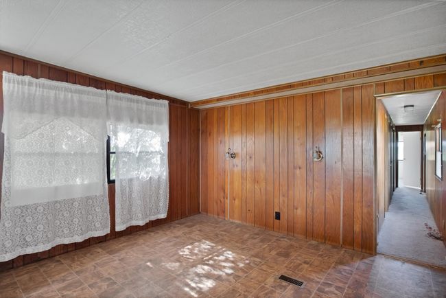 Unfurnished room featuring wood walls and tile patterned floors | Image 8