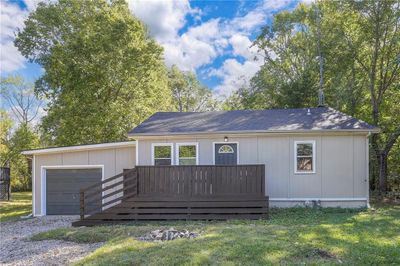 View of front facade featuring a garage, a deck, and a front lawn | Image 1