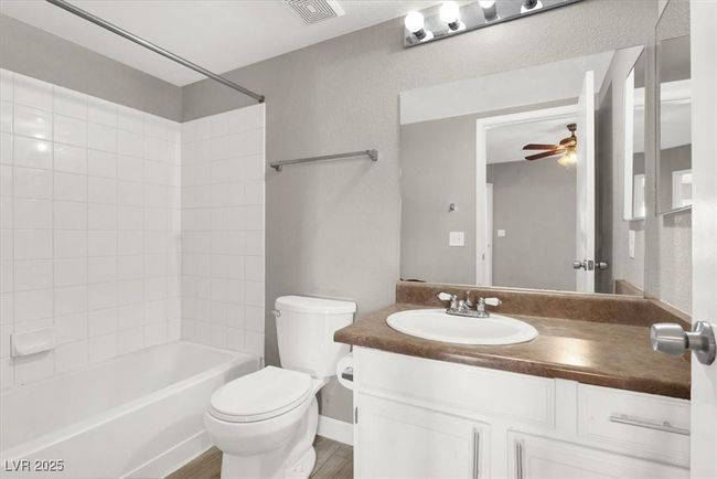 Full bath with washtub / shower combination, visible vents, toilet, vanity, and ceiling fan | Image 17